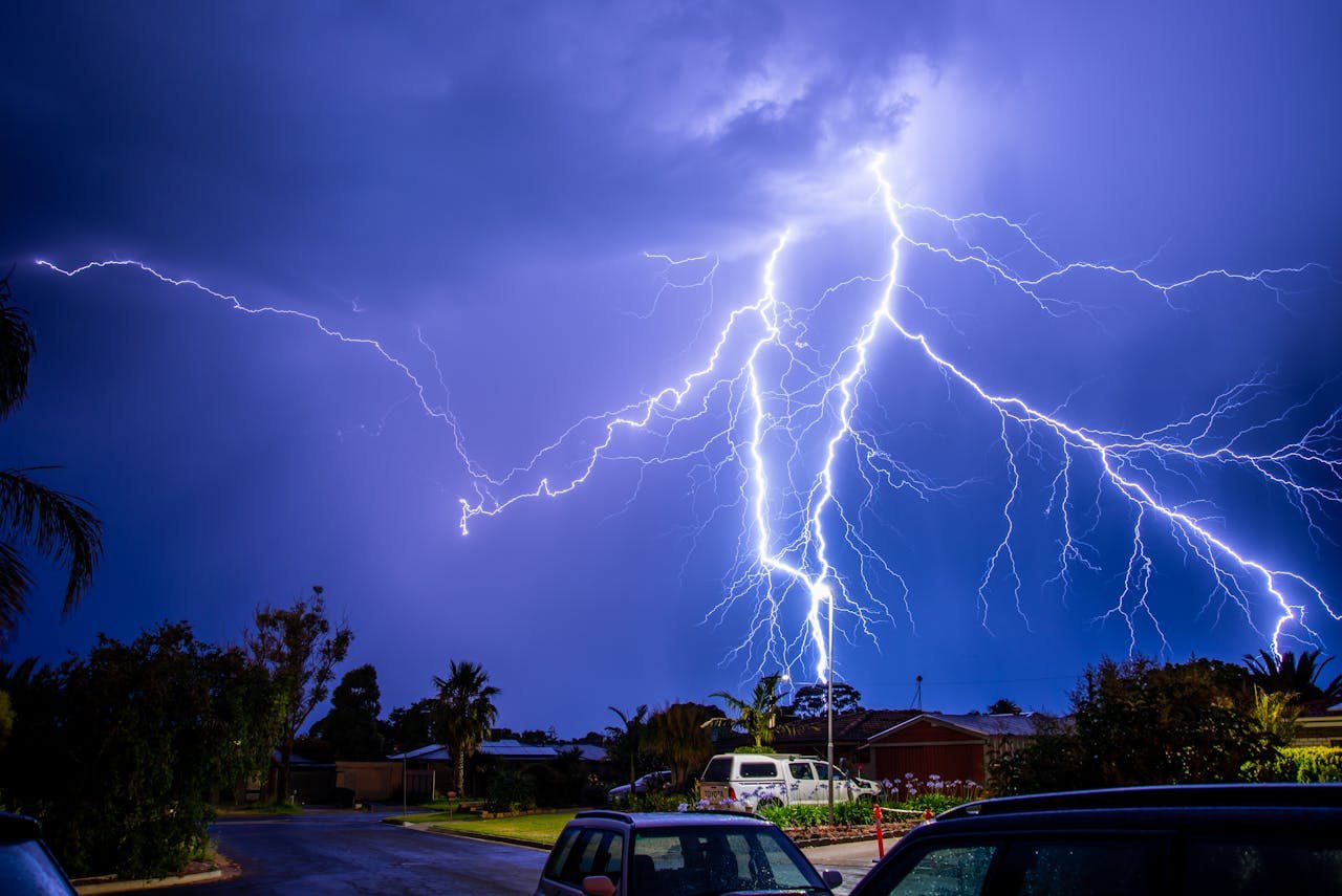 Lightning storm near trees in residential area